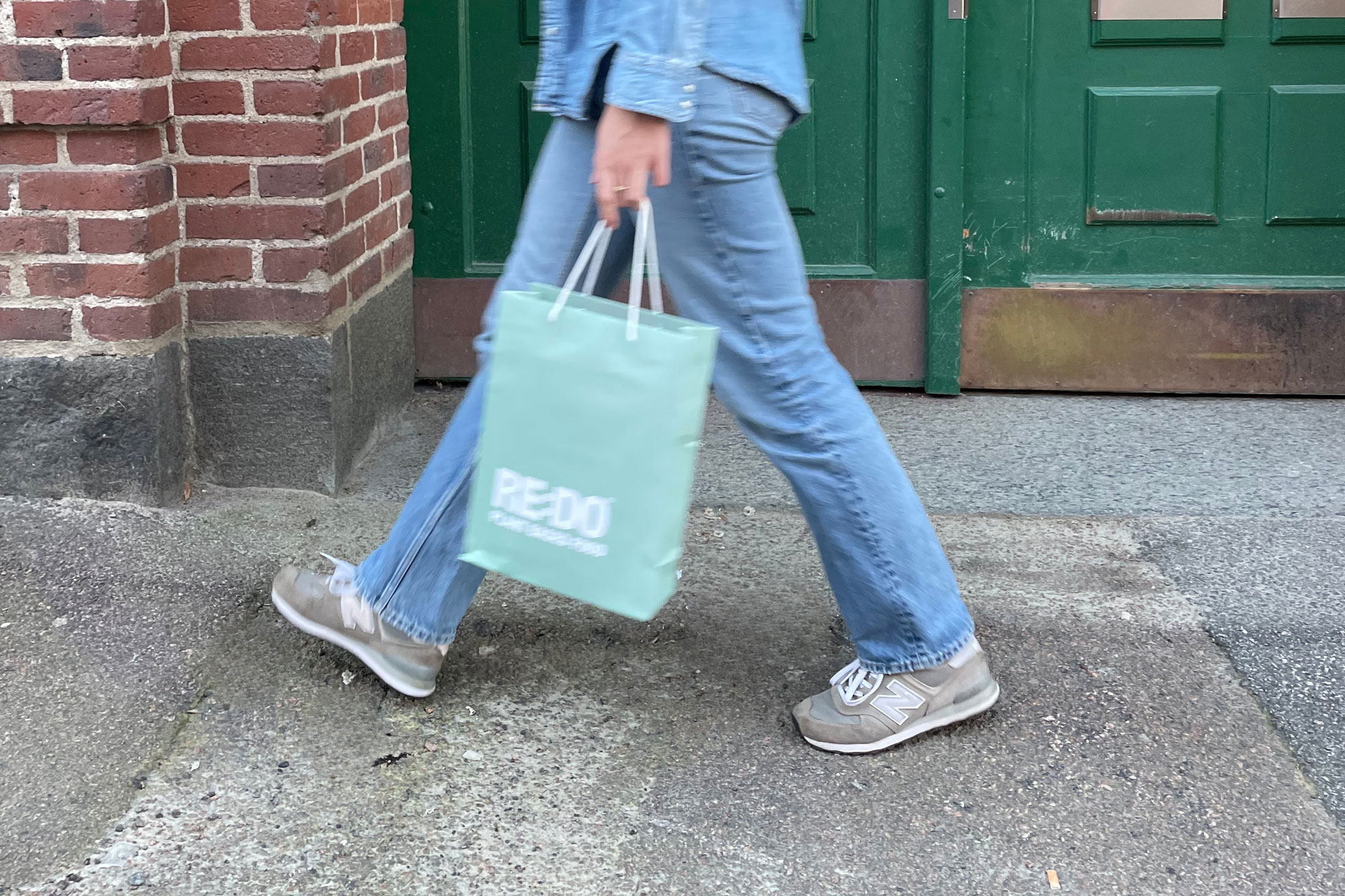 A person walking with a RE:DO bag in her hand